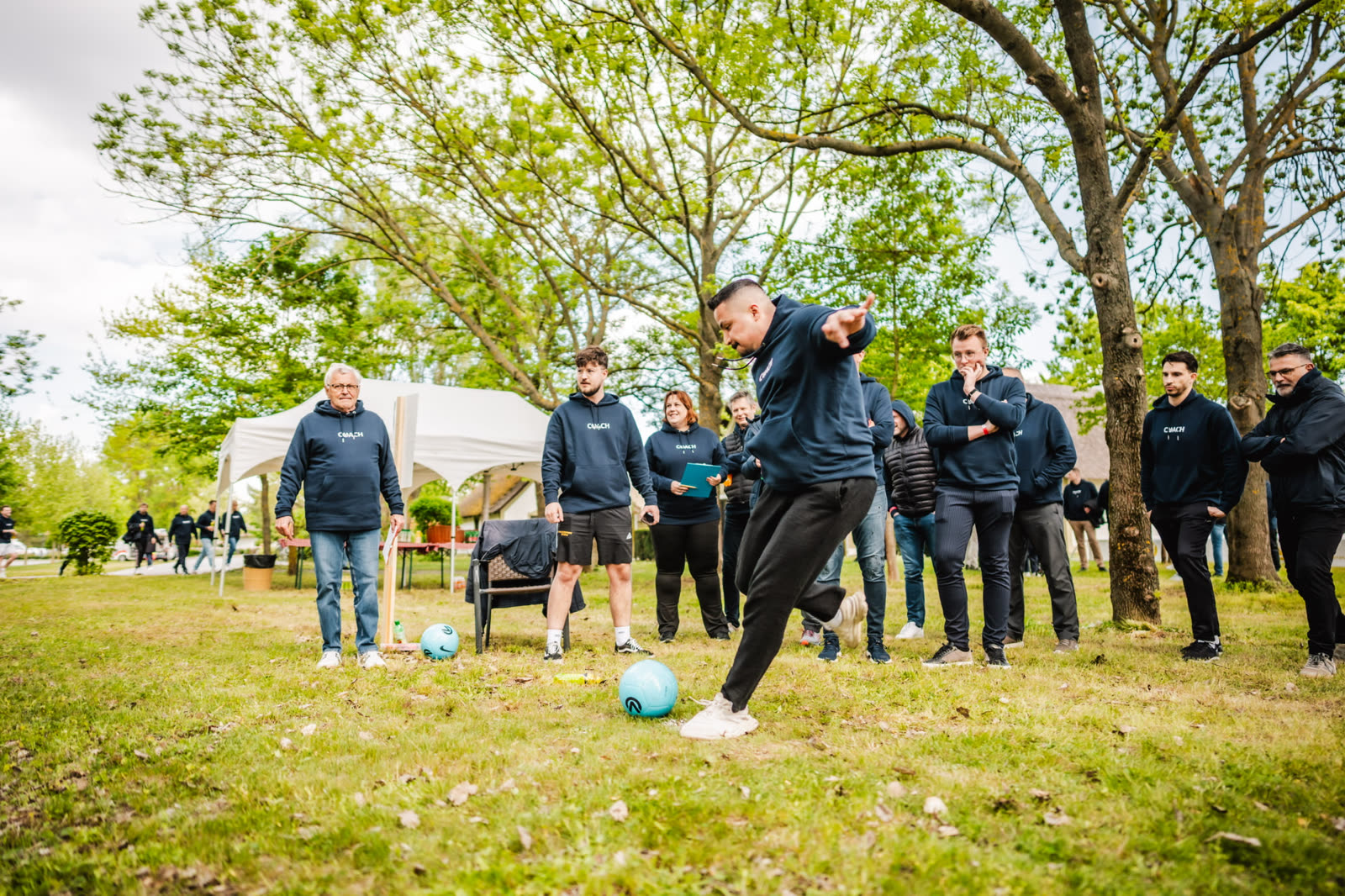 Teamevent im Freien: Kollegen beim Fußballspielen im Park